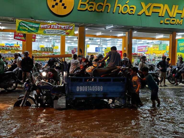 Các thành viên đội cứu hộ S.P.D đưa xe chết máy lên ba gác ở đường Phạm Hữu Lầu, phường Tân Mỹ, TP HCM. Ảnh Nhân vật cung cấp
